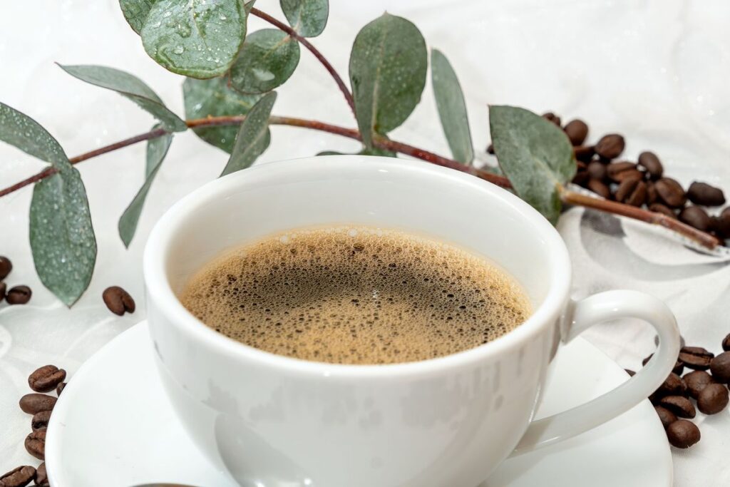 The ARC of the Sun: A Simple Daily Rhythm for Getting More Done Steaming cup of coffee styled with coffee beans and eucalyptus leaves, morning still life