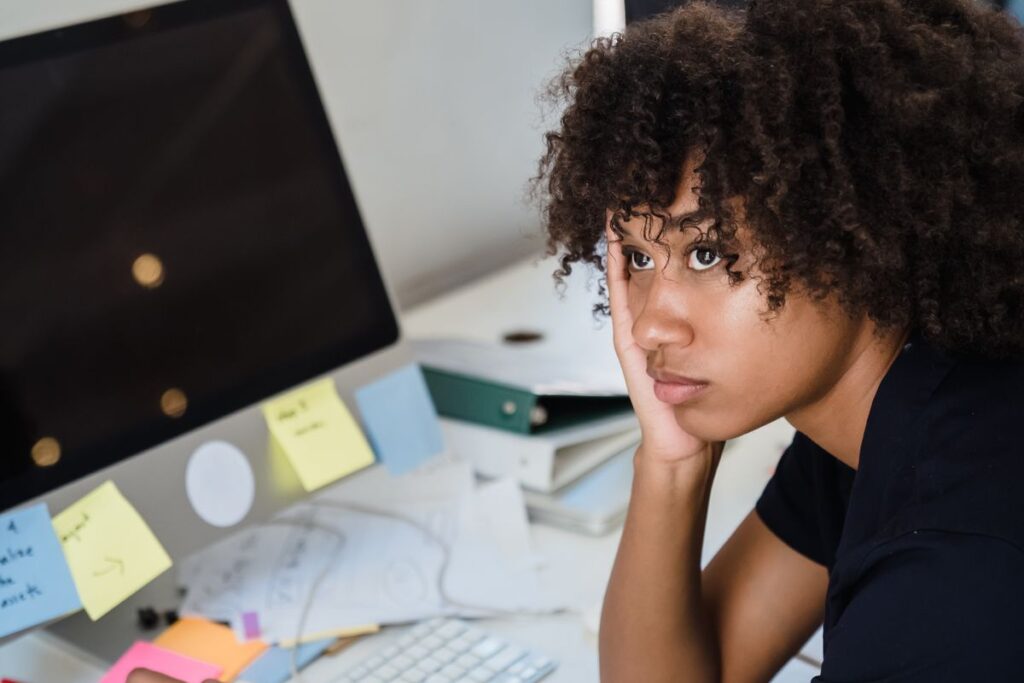 Why Willpower Fails (And What Actually Works Instead) Tired woman resting her head at her work desk